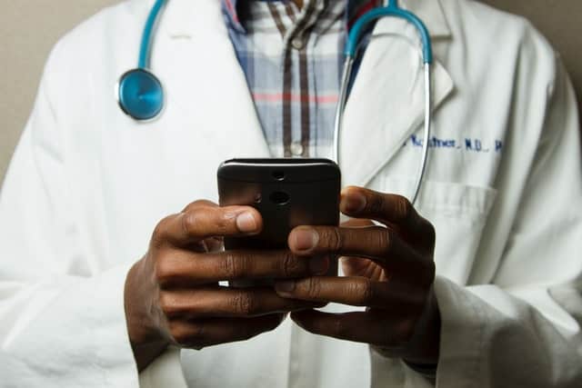 doctor holding smart phone, telehealth