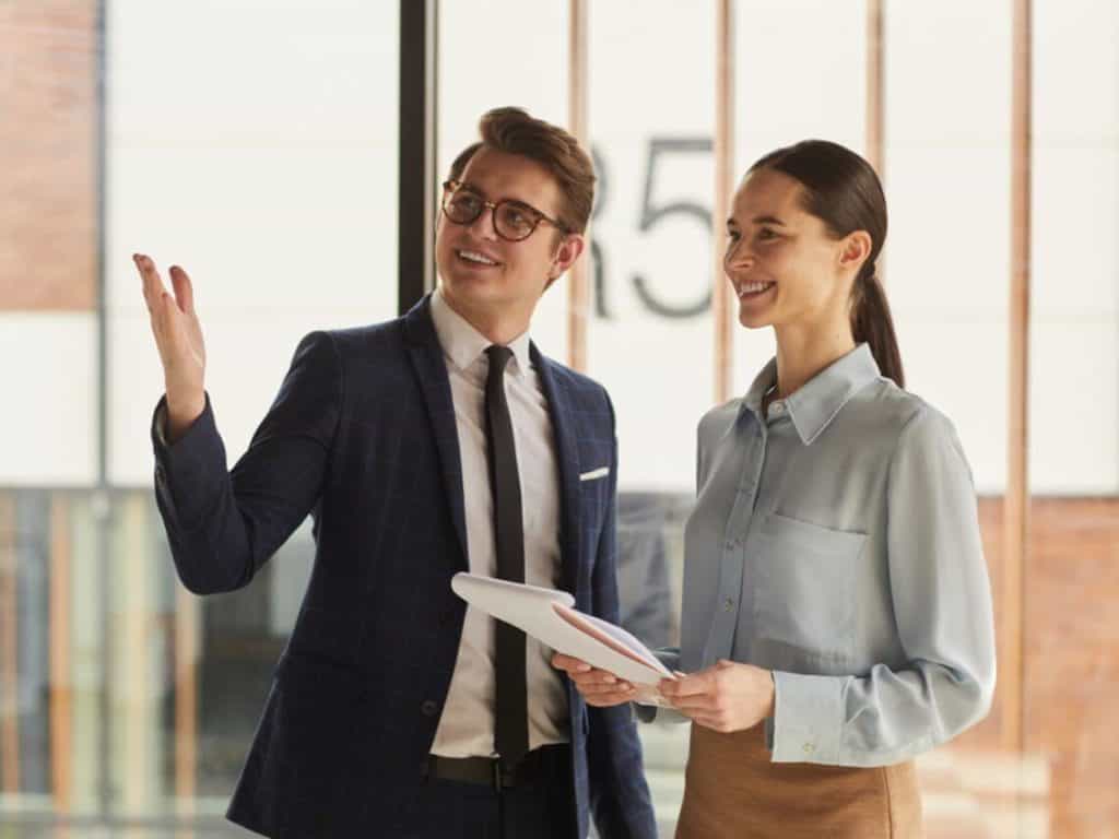 A real estate broker is speaking with a client inside an office space