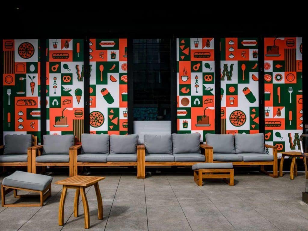 Colorful art displays hanging behind a line of chairs inside a medical practice waiting room