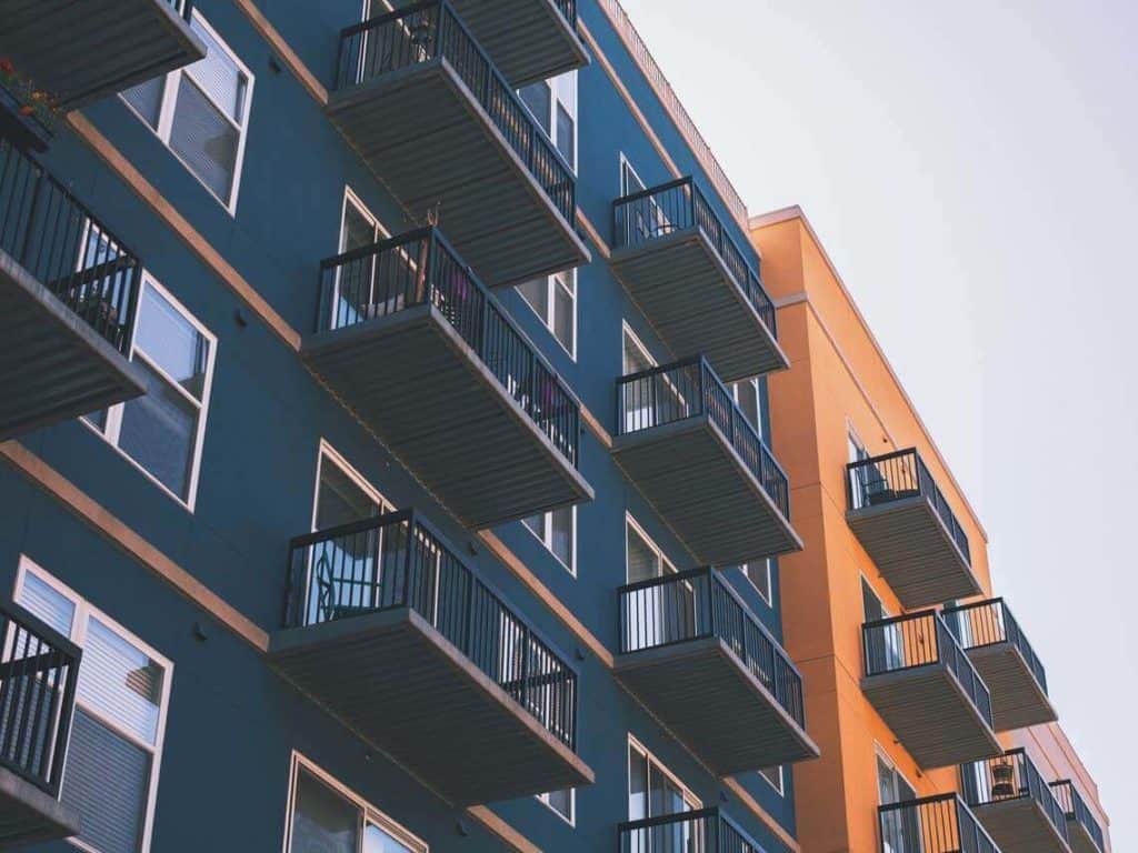 A blue and Orange Mixed-Use Developments with a row of balconies