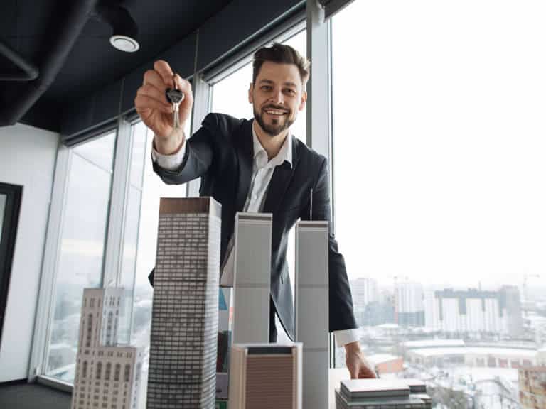 Man holding keys to signify buying commercial real estate