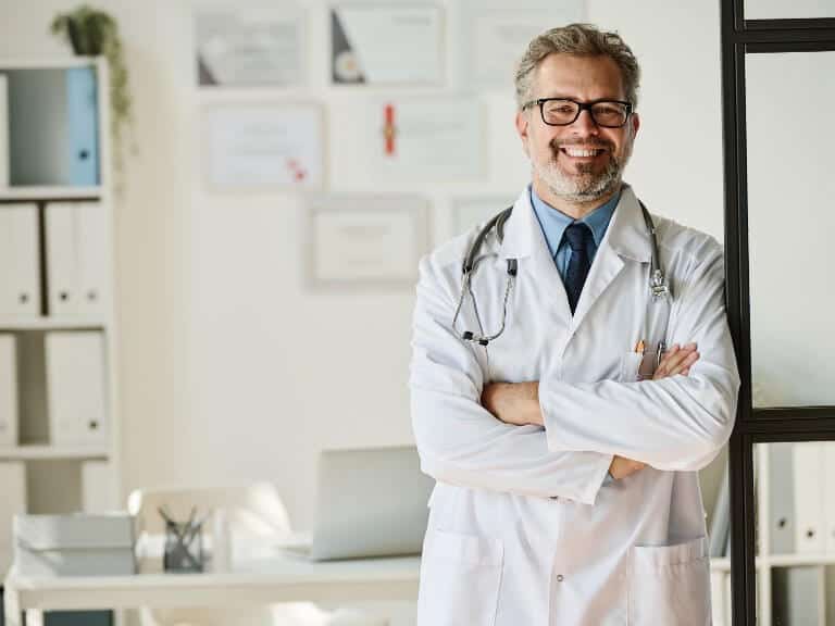 Mature male doctor standing and smiling in a medical office setting