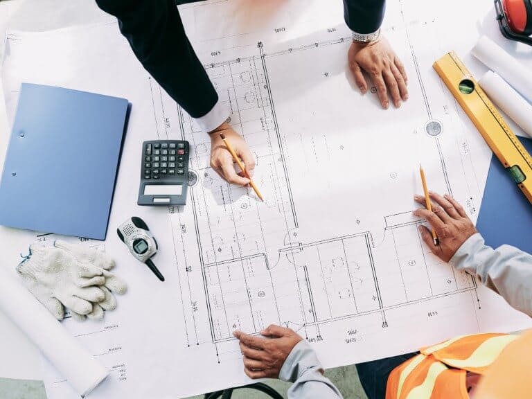 Real estate planners analyze a blueprint sheet